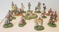Multiple miniature cast iron figurines displayed, showcasing their variety, colors, and bases.