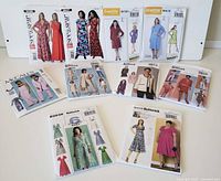 Photo showing 11 vintage and classic sewing patterns including Butterick, McCall's, and Lisette brands laid out on a flat surface with various dress and outfit designs.