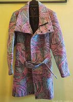 Front view of the Samuel Dong coat hanging on a hanger showing the full length and pattern