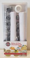Front view of boxed Norpro Deluxe 18 Piece Decorating Set showing piping tips, piping bags, and other accessories inside clear plastic case.