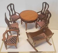 7 piece miniature dark wood dining room set arranged showing table, four chairs, armchair, and cradle