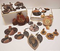 Overview of handcrafted polymer jewelry displaying various earrings, pendants, and brooches with detailed textures and earthy colors.