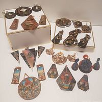 Wide view showing entire lot of handcrafted polymer jewelry including earrings and pendants in varied geometric shapes and painted finishes.