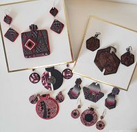 Full view of the polymer clay earrings and pendants displaying various geometric shapes and patterns in red, black and silver