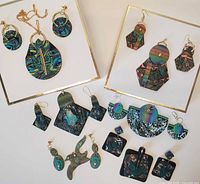 Full spread of polymer clay jewelry including various earrings and a necklace laid out on white background