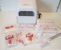 Multiple packs of false nails in various sizes, several tubes of glue, and more small bags containing nails