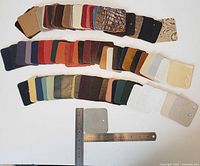 Wide view of 100 leather sample squares arranged in rows by color and texture, showing the variety of finishes and hues.