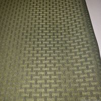 Close-up of green fabric with woven brick pattern design