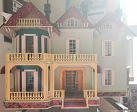Front view of assembled dollhouse exterior showing porch and balconies