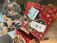 Lot overview showing four mugs, glass pitcher, two boxed plates