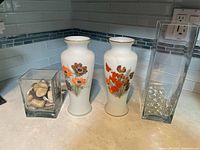 Front view of all four vases showing designs and contents