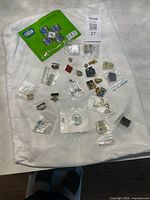 Full lot on fabric showing all pins in bags and puzzle set