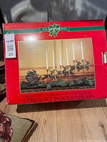 Front of Traditions box showing brass reindeer candlestick sleigh set