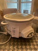 Front view of Rival Crock-Pot Smart-Pot slow cooker with lid and tag