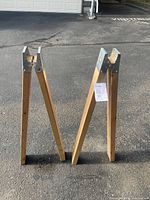 Two wood and metal stands upright on driveway