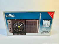 Front of box showing Braun ABR 313 sl radio alarm clock with FM radio and snooze features.