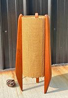 Front view of lamp showing teak tri-pod base and cylindrical shade