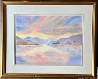 Framed watercolour painting showing mountain lake scene with pastel sky and water reflections.