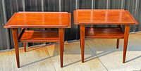 Pair of teak side tables shown side by side outdoors against corrugated metal backdrop
