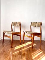 Pair of chairs front view on hardwood floor against white wall