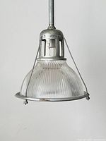 Front view of the industrial pendant light showing the ribbed clear Holophane glass shade and steel frame.