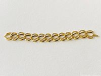 Full length view of vintage Napier gold plated linked bracelet laid flat on a white surface showing the uniform oval links and clasp end.