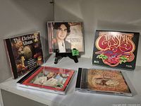 Five Christmas CDs displayed on a shelf with front covers visible.