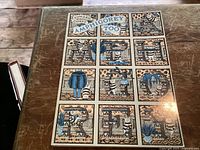 Front cover of the softcover book titled Amphigorey Too, showing detailed whimsical illustrated tiles forming title letters, corner of cover bent