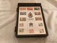 Closed view of brown plastic Canada Centennial Stamp Box with commemorative stamp set design on lid.