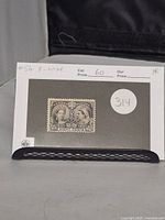 Photo showing the 8 cent dark violet Jubilee stamp mounted on a display card with catalog and price information