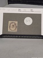 Full front view of Canadian 10 cent Queen Victoria stamp mounted on gray backing card with handwritten catalog number and condition noted.