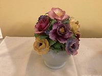 Front view of Coalport porcelain flower basket sculpture on white cloth background.