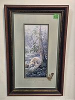 Full view of the framed picture showing the artwork, frame, and attached feather.