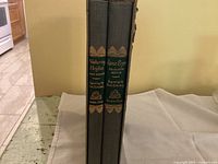 Side view of the two hardcover books in the slipcase showing titles and spine details.