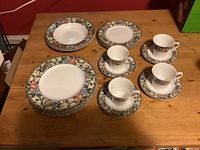 Full set of Mikasa Chelsea Court dinnerware showing 5 dinner plates, 3 salad plates, 3 soup bowls, 4 cups with saucers, floral pattern with gold trim