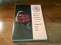 Photograph of the book 'Rock and Mineral Collecting in Canada Volume II Ontario and Quebec' showing front cover with image of a rock and title text.