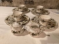 Full set showing 4 place settings of dinner and bread plates, cups with saucers, cream and sugar containers