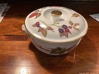 Covered casserole dish with floral Evesham pattern and gold accented lid knob and handles shown from the top angle.