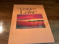 Front cover of 'The Golden Lake Story' softcover book showing sunset lake image and author name H. Eleanor (Mooney) Wright.