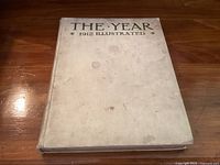 Cover of 'The Year 1912 Illustrated' book, cloth bound with signs of age and wear.
