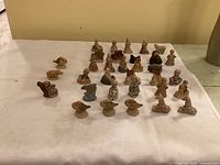Wide view of all 33 Wade Whimsies figurines arranged in rows on white background showing different characters and animals