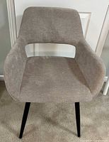 Front view of gray fabric accent chair showing slightly worn fabric and black legs.
