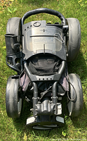Folded Caddytek foldable 4 wheel push cart showing the top side with handle and wheels stacked 