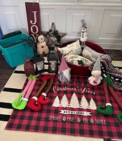 Photo of Christmas lot showing all items arranged on floor including floor mat, lanterns, gnomes, snowmen, textiles, and wooden decor