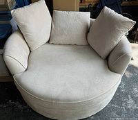 Front view showing overall circular shape, curved arms, seat cushion and three back cushions