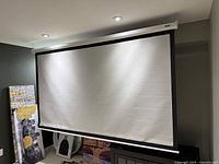 Front view of screen fully extended showing matte white surface bordered by black trim