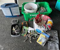 Full lot showing various hardware items including organizer, buckets, hooks, handles, and ratchet sets on dark carpeted floor.