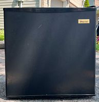 Front view of the black mini fridge showcasing overall condition and size.