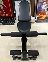 Front view of bench showing backrest, seat, and leg developer with foam rollers