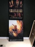 Two laminated wood print movie posters displayed vertically against a wall, one "Pirates of the Caribbean" on top and one "Spider-Man" on the bottom.